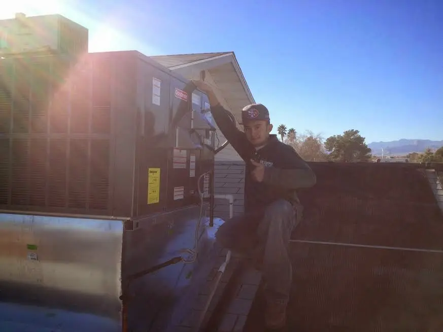 HVAC technician performing Boiler Repair on a rooftop unit in De Queen